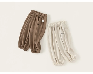 Détail de joggings pour enfants en marron et crème avec chevilles resserrées et broderie