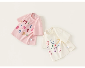 Detailansicht von sommerlichen T-Shirts in Rosa und Off-White mit bunten Grafikprints