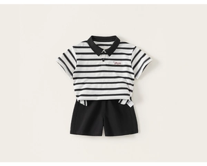 Detailed close-up of striped kids polo shirt with red Dream embroidery and black shorts