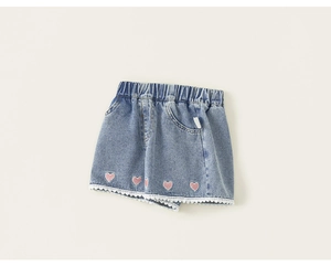 Detail of girls' denim shorts showing elastic waist and pink heart embroidery with lace trim