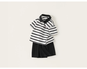 Detail of children striped polo shirt with Dream embroidery and black shorts