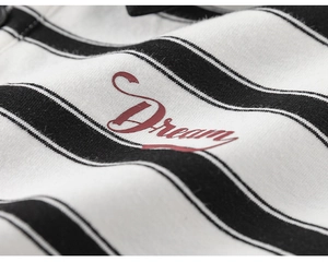 Macro shot of striped cotton fabric featuring a red Dream print for kids outfit