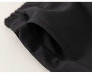 Detail of side pocket stitching and elastic waistband on black knitted cotton shorts