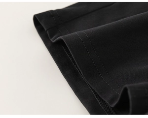 Detail shot of black knitted fabric with reinforced double-needle stitching on the hem