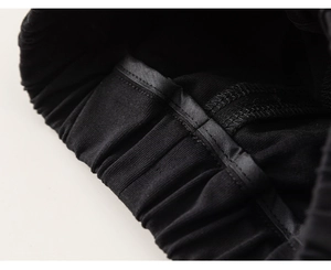 Close-up of fine stitching and elastic waistband texture on kids black cotton shorts