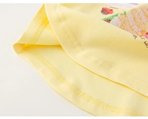 Close-up of yellow knit cotton fabric with fine texture and colorful cupcake print
