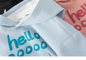 Détail de l'imprimé 3D en relief hello sur des sweats à capuche bleu rose et noir
