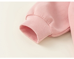 Gros plan des poignets côtelés élastiques sur un sweat à capuche rose pour petite fille