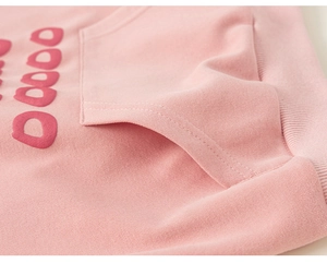 Détail d'un sweat à capuche rose pour enfant avec ourlet côtelé et lettrage imprimé en 3D