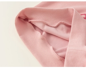 Détail du poignet d'un sweat-shirt rose pour fille montrant la finition en tricot côtelé