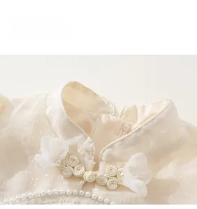 Detail von Stehkragen mit Perlenknöpfen und floralen Akzenten auf einem Qipao-Kleid