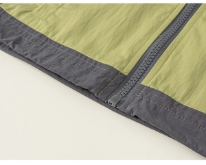 Detailansicht der zweifarbigen Kinderjacke mit Fokus auf Reißverschluss und Doppelnähten