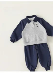 Détail de l'ensemble polo et pantalon pour enfant bleu marine et gris avec broderie