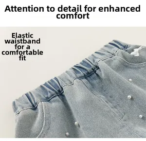 Dettaglio di pantaloncini in denim azzurro con vita elastica e decorazioni in perline