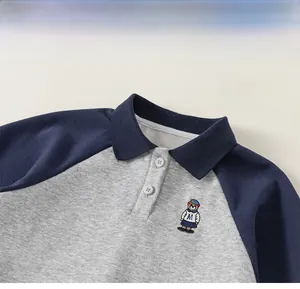Détail du sweat polo garçon avec col bleu marine et broderie d'ours sur la poitrine