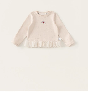 Détail du haut à manches longues pour bébé avec broderie arc-en-ciel et tulle