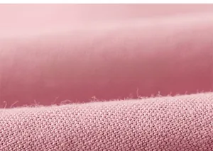 Close-up of soft pink textile fabric texture showing fine weave for kids apparel