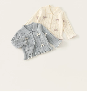 Detail von Strickjacken für Babys mit feinen Lochmustern und Muschelsaum-Abschluss