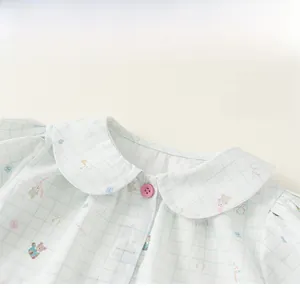 Close-up of Peter Pan collar on blue plaid baby shirt with bear prints and pink buttons