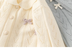 Nahaufnahme der Mädchen Strickjacke mit feinem Lochmuster und süßen Schleifendetails