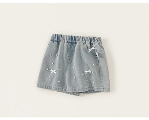 Dettaglio dei pantaloncini di jeans azzurri con perline e fiocchi decorativi per bambine