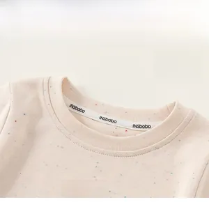 Détail du col d'un pull pour bébé fille avec tricot confetti et broderie arc-en-ciel