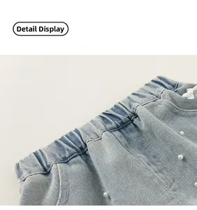 Dettaglio della vita in denim azzurro con elastico e decorazioni con perline di perle