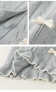 Detailansicht der hellblauen Strickjacke mit weißen Schleifen und Wellensaum