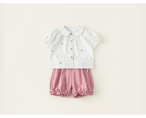 Detail of baby girl summer outfit featuring doll collar shirt and pink bloomers