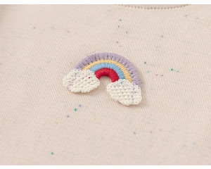 Détail d'un t-shirt pour fille avec broderie arc-en-ciel et nuages en crochet