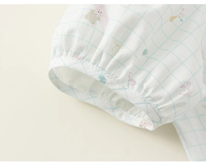 Detail of baby girl doll shirt elastic cuff with cute cartoon rabbit and floral print