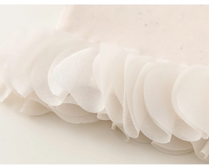 Gros plan sur tissu rose à pois avec volants en dentelle blanche et couture soignée