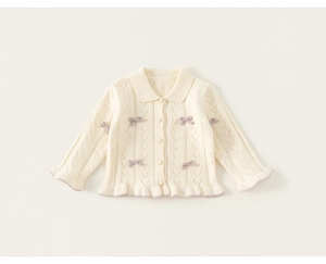 Detail der Strickjacke in Elfenbein mit lila Schleifen und gewelltem Saum für Kinder