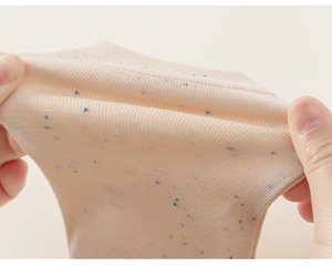 Détail du tissu en maille côtelée beige élastique avec mouchetures colorées pour enfant
