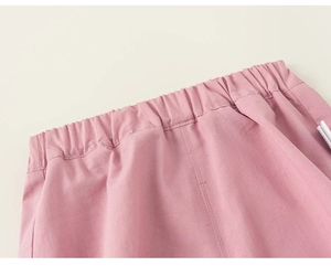 Detailed close-up of pink cotton linen shorts featuring an elastic waistband with stitching