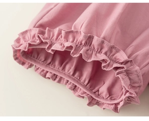 Close-up of ruffled hem and elastic pleats on soft pink cotton children's clothing