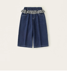 Detail der Mädchen-Denim-Hose mit kariertem Rüschenbund und tiefblauem Stoff in A-Linie