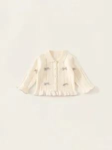 Mädchen Strickjacke in Creme mit lila Schleifen und feinen Rüschendetails am Saum