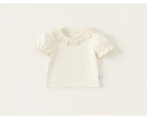 Detailed close-up of embroidered lace collar and soft cotton fabric on a girl's cream t-shirt