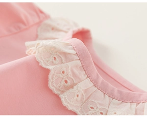 Detailed close-up of pink cotton T-shirt featuring white embroidered lace ruffle collar