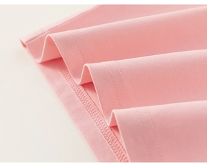 Close-up of pink cotton T-shirt featuring precision double-needle stitching on the hemline