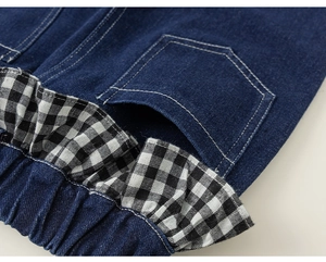 Detail der dunkelblauen Denim-Hose mit Gingham-Rüschenbund und weißen Kontrastnähten