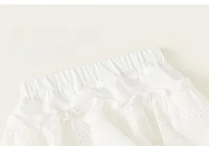 Dettaglio gonna bianca da bambina con vita elastica e delicati volant in pizzo floreale