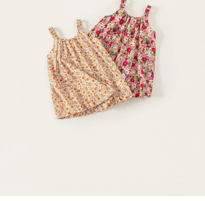 Flat lay detail showing floral cotton toddler sundresses in yellow and red patterns