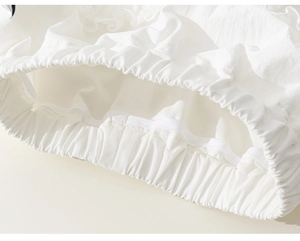 Dettaglio ravvicinato del tessuto di cotone bianco con punto smock elastico e pizzo