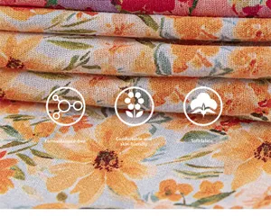Close-up of soft floral cotton fabric with orange daisy print and skin-friendly texture