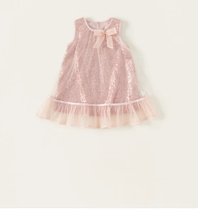 Détail de la robe rose en tulle avec des paillettes brillantes et un nœud en soie