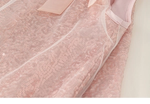 Détail de paillettes roses, tissu tulle et nœud en satin sur une robe de princesse