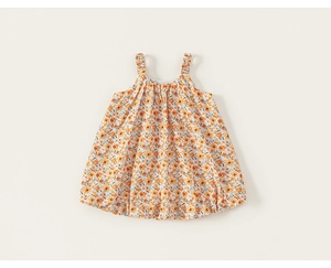 Detailed view of girl's floral suspender dress with orange blossoms and pleated straps