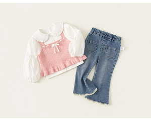 Detail of girls knit vest with bow and flared jeans featuring crochet lace trim